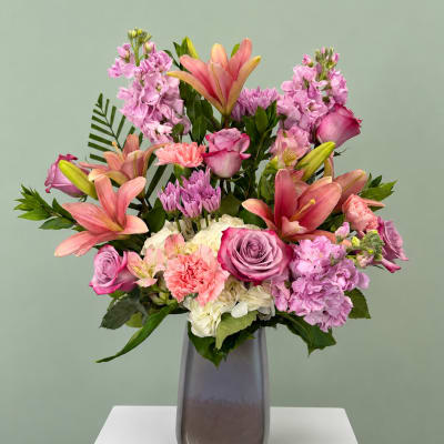 Pink and lavender mixed bouquet in a tall gray vase