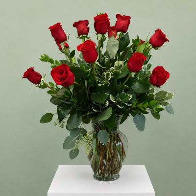 Red roses arranged in a clear glass vase