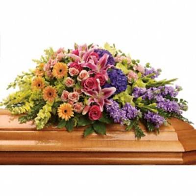 Colorful floral casket spray with lilies, roses, and daisies