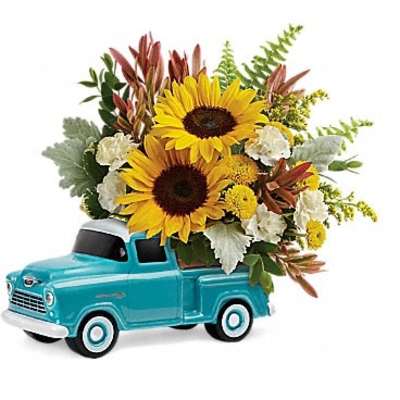 Sunflowers arranged in a turquoise toy pickup truck