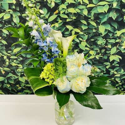 Blue and white flowers arranged in a clear glass vase