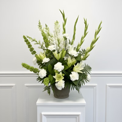White and green floral arrangement in a dark vase