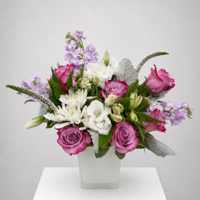 Pink and white mixed flower arrangement in a square white vase