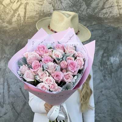 Large bouquet of pink roses wrapped in pastel paper