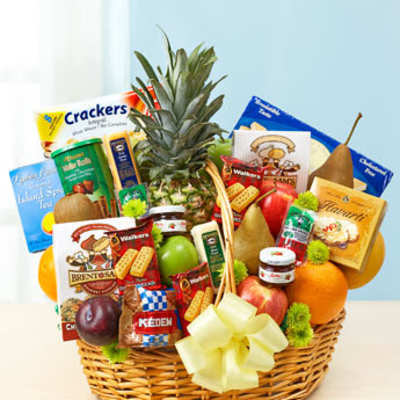 Large wicker gift basket filled with assorted fruits, snacks, and a yellow bow