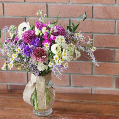 Mixed bouquet of purple, white, and pink flowers in a glass vase