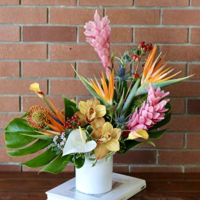 Tropical bouquet in a white vase with pink and orange flowers