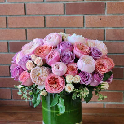 Pink and lavender roses arranged in a glass vase