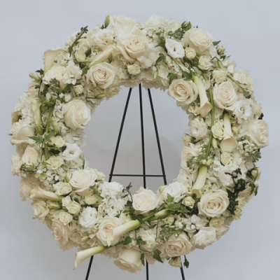 Cream floral wreath on a black stand