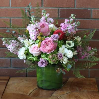 Pink and white mixed bouquet in a green glass vase