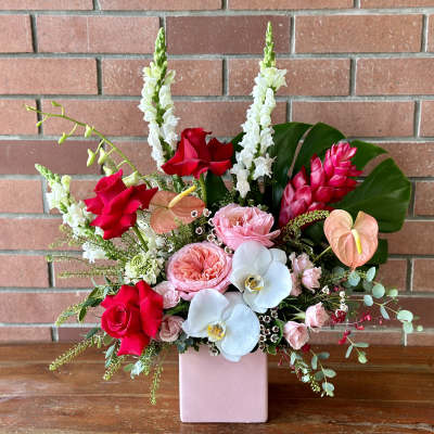 Mixed bouquet in a pink vase with red, pink, white, and peach flowers