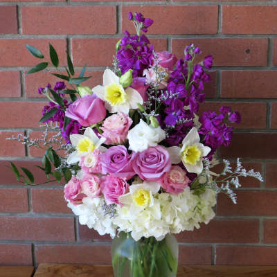 Mixed pink, white, and purple flowers in a glass vase