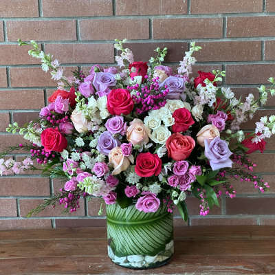 Mixed pink, lavender, and white roses in a glass vase
