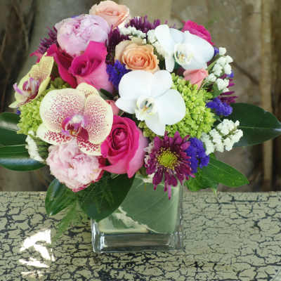 Mixed bouquet with orchids, roses, and chrysanthemums in a glass vase