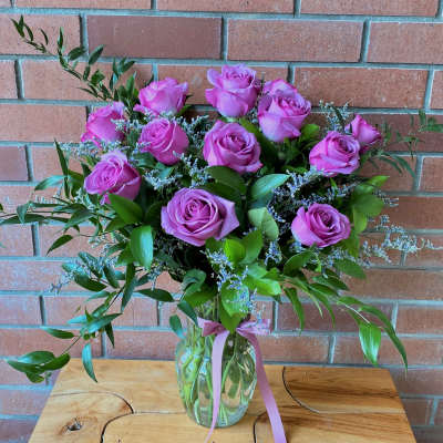 Pink rose bouquet in a clear glass vase with a ribbon