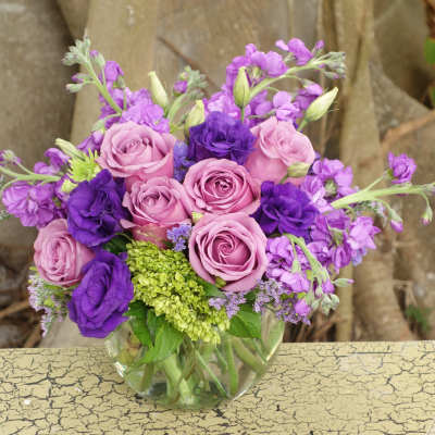 Pink and purple rose bouquet in a clear glass vase
