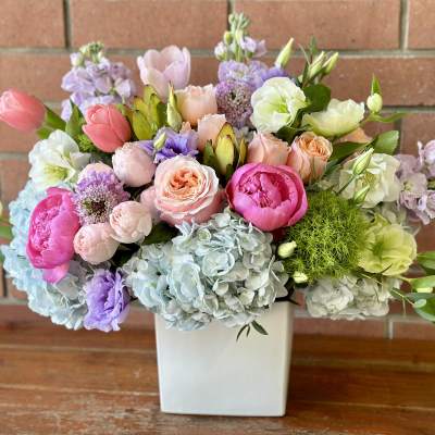 Mixed pastel bouquet in a white square vase