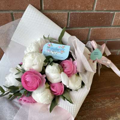 Bouquet of pink and white ranunculus wrapped in white paper