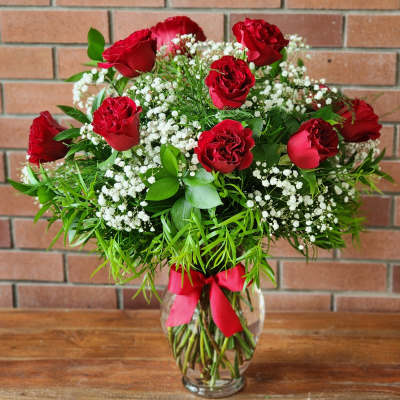 Red roses in a glass vase with white baby's breath