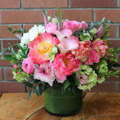 Pink and white mixed bouquet in a green glass vase