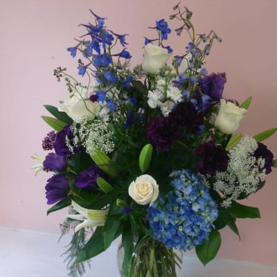 Bouquet of blue, white, and purple flowers in a glass vase