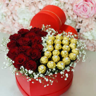 Heart-shaped box with red roses and gold-wrapped chocolates
