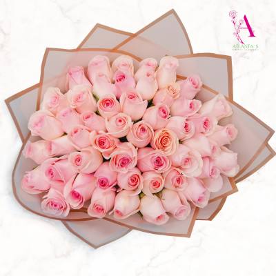 Large bouquet of pale pink roses wrapped in translucent paper