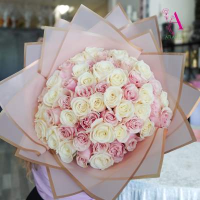 Large bouquet of pink and white roses wrapped in pale pink paper