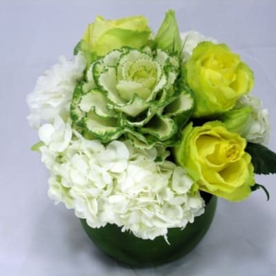Green and white floral arrangement in a dark green vase