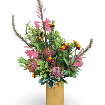 Tall mixed bouquet in a gold vase with pink and orange flowers