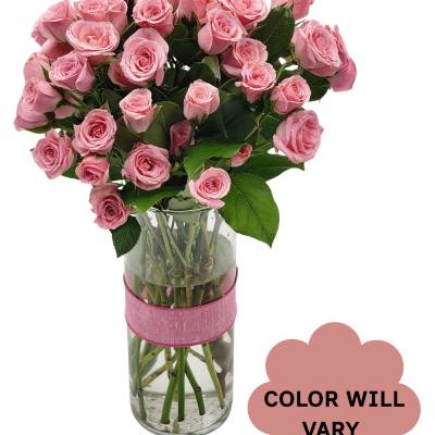 Bouquet of pink roses in a clear glass vase with a pink ribbon