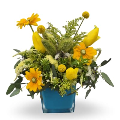 Yellow mixed bouquet in a blue square vase