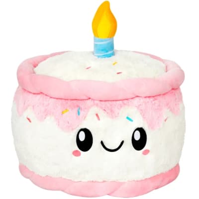 Pink and white plush cake-shaped candle with a smiling face