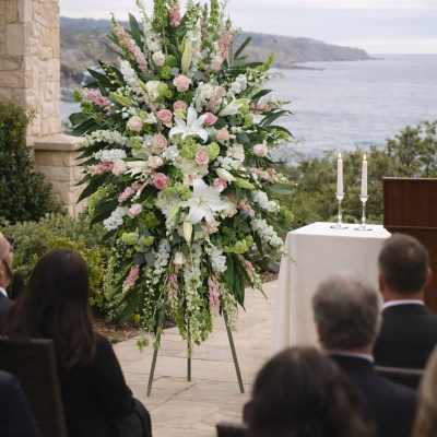 Tall wedding floral arrangement with pink and white flowers on an easel
