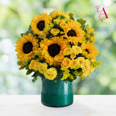 Yellow sunflowers and roses arranged in a green glass vase
