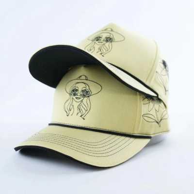 Two beige baseball caps with black line drawings and black brims