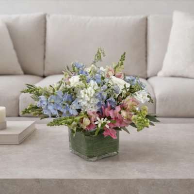 Pastel mixed flower arrangement in a square glass vase