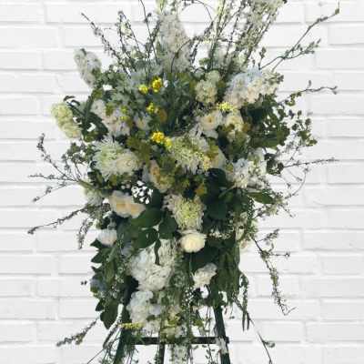 Large white floral standing spray on an easel