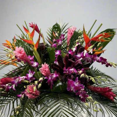 Tropical arrangement with purple orchids, pink flowers, and orange heliconia