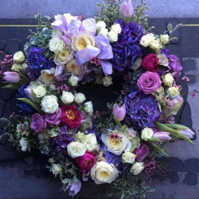 Circular floral wreath with purple, white, and pink blooms
