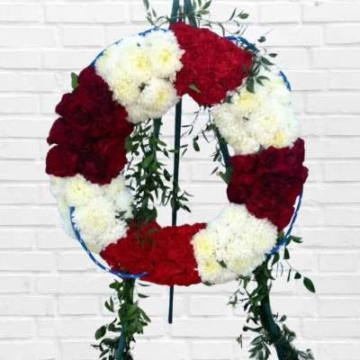 Circular wreath of red and white flowers on a stand