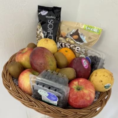 Fruit basket with apples, kiwis, oranges, and packaged snacks