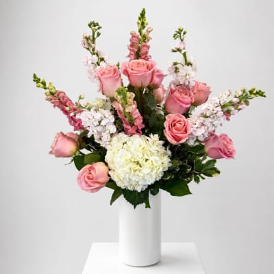 Pink roses and white hydrangea in a white vase