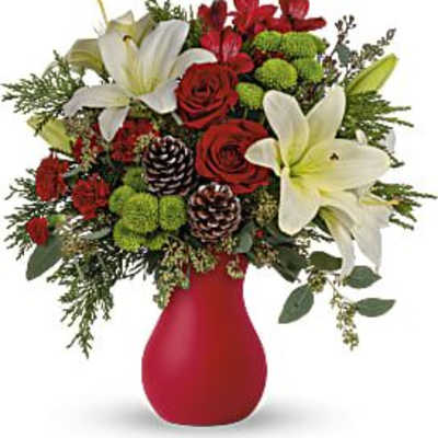 Red roses and white lilies in a red vase with pinecones