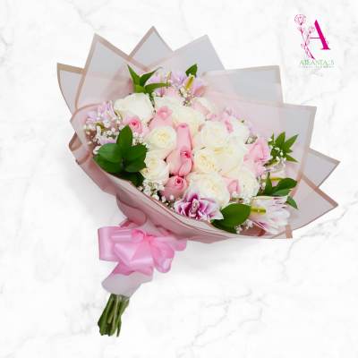 Pink and white rose bouquet wrapped in translucent paper with a pink ribbon