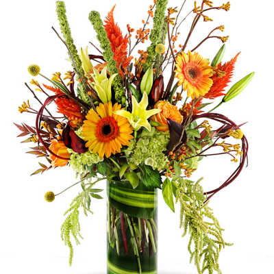 Tall autumn bouquet with orange gerbera daisies and lilies in a glass vase