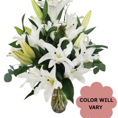 White lilies arranged in a clear glass vase