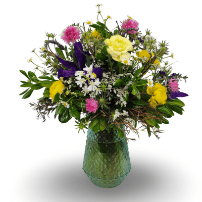 Mixed bouquet of yellow, pink, purple, and white flowers in a green glass vase
