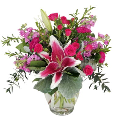 Pink and white mixed flower arrangement in a clear glass vase