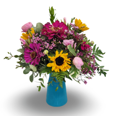 Mixed bouquet of pink, purple, and yellow flowers in a blue vase